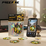 Free Fire Booyah! sticker set featuring colourful game-inspired character designs, displayed on a holographic package, desk, and smartphone.