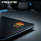 Free Fire Booyah! sticker set featuring colourful game-inspired character designs, displayed on a holographic package, desk, and smartphone.