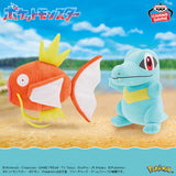 Banpresto Pokémon plush toys featuring orange Magikarp with a yellow crown-like fin and large white fins, alongside blue Totodile with a yellow belly and red eyes.