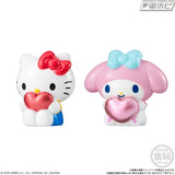 Sanrio Hello Kitty puffy balloon mascot featuring a white Hello Kitty figure with a red bow, holding a shiny red heart, displayed alongside its colourful product packaging.